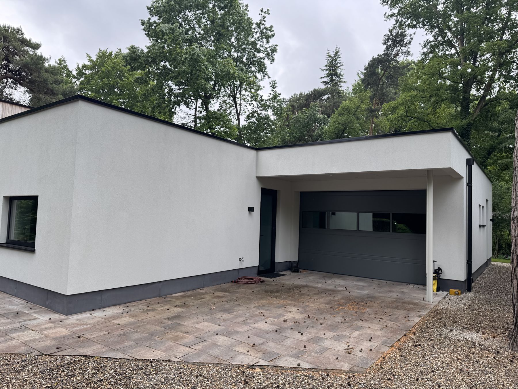 Wit gestucte vleugel met garagedeur en strakke hoeken